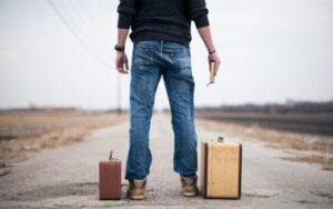 photo of man on road with suitcases