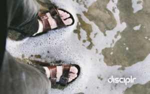 photo of feet in sandals on seashore